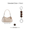 A brown leather pouch with an extended chain and a separate pendant charm.