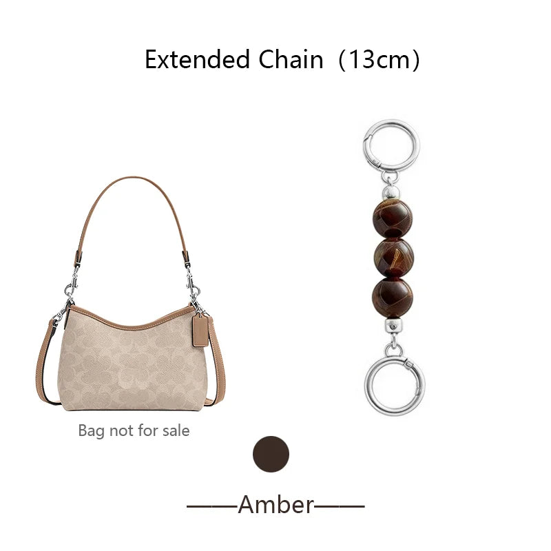A brown leather pouch with an extended chain and a separate pendant charm.