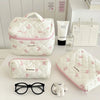 Collection de sacs de rangement cosmétiques rembourrés blancs avec motifs de nœuds roses, accompagnés de lunettes de soleil e