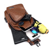 A brown leather men's chest bag featuring a headphone port, alongside a black wallet and a yellow accessory.