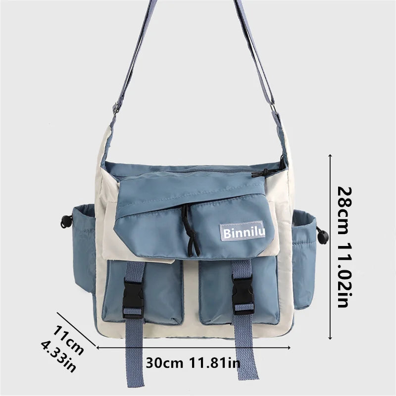 Bolso cruz de nylon azul claro y blanco con correas ajustables sobre fondo gris.