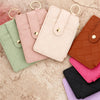 A collection of five pink, green, beige, and brown PU leather card holder wallets with gold rings.