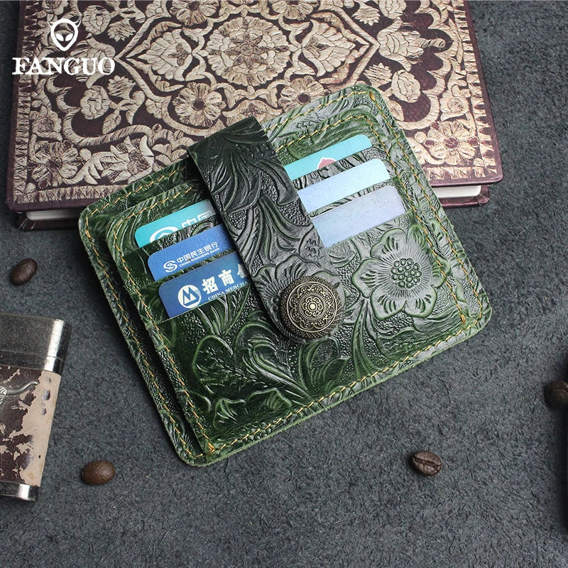 A green leather card wallet with a textured cover and multiple cards resting on a dark gray fabric.