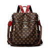 A brown genuine leather women's backpack with red straps and gold hardware.