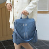 A light blue leather anti-theft women's backpack with a patterned fabric and silver zippers.
