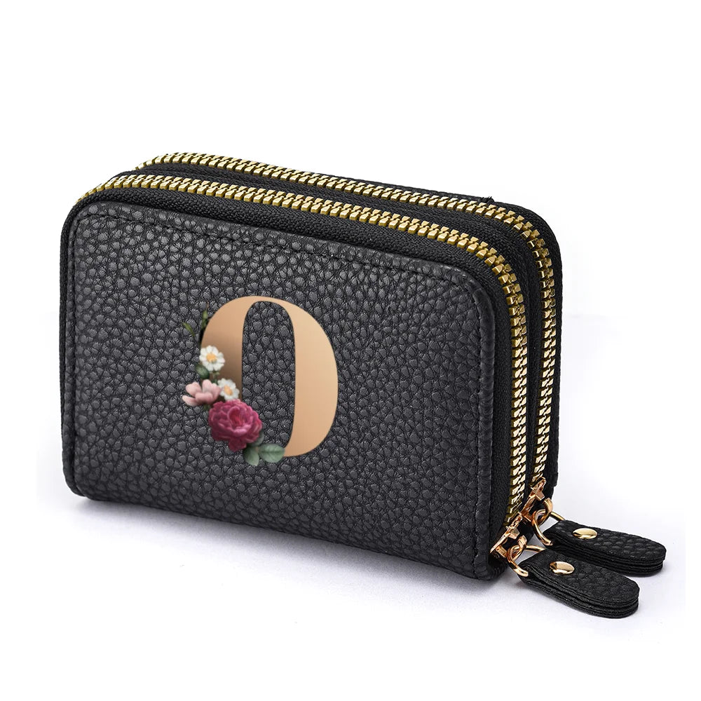Black faux leather mini wallet with a gold zipper and a rose floral letter print