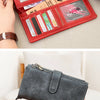 A close-up of a red vintage trifold clutch wallet being opened and closed by a hand.