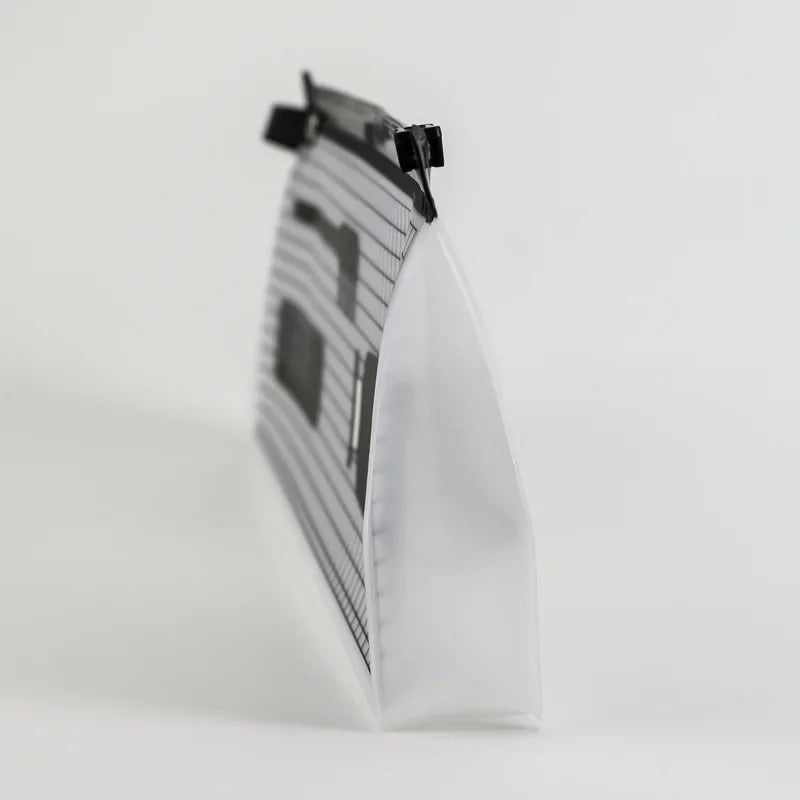 Bolsa de almacenamiento cosmético transparente con tapa estampada negra, vista de lado.