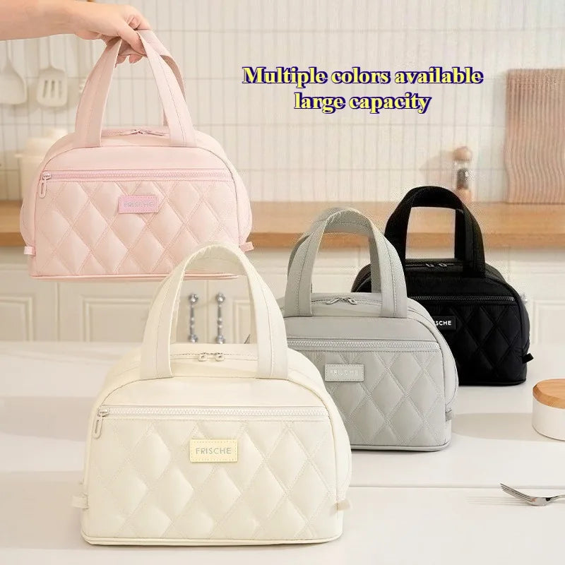 A collection of quilted lunch totes in pink, gray, and black are displayed on a white surface.