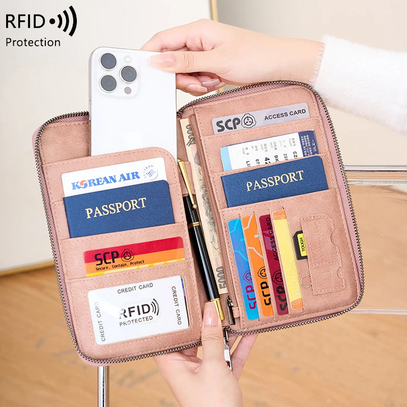 A brown RFID blocking travel wallet holds a passport, credit cards, and an ID card, with a smartphone visible above it.