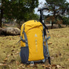 A yellow and gray durable 80L waterproof hiking backpack resting on dry grass.