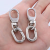 A pair of silver metal swivel lobster claw clasps with key rings shown on a hand.
