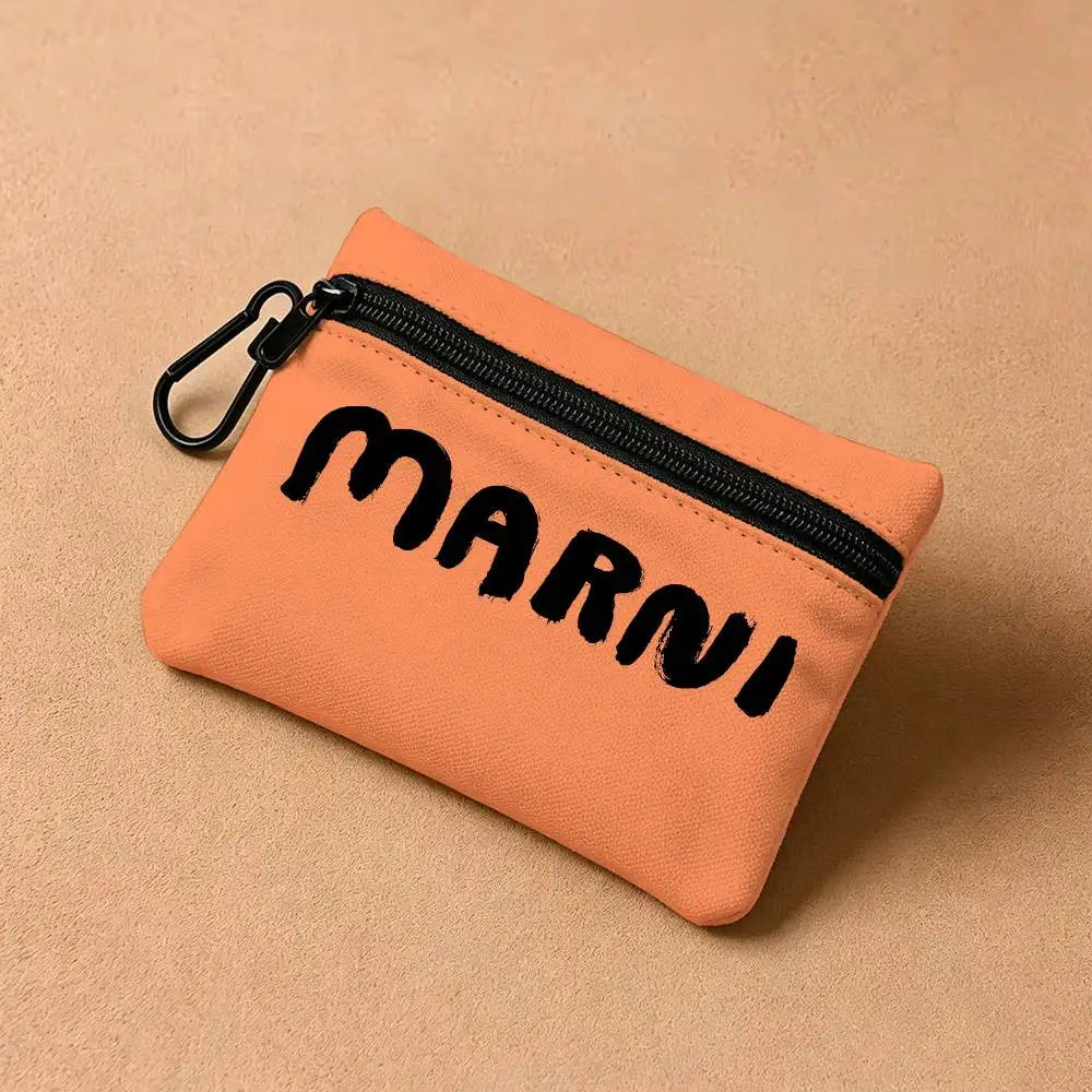 A small orange coin purse with a black zipper and the word MARNI printed on it, resting on a neutral background.