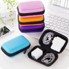Une pile de sacs de rangement portables colorés pour appareils électroniques et câbles à côté d'un ordinateur portable et d'u