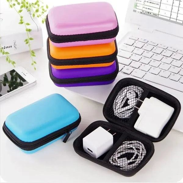 A stack of colorful portable storage bags for electronics and cables next to a laptop and a single blue bag.