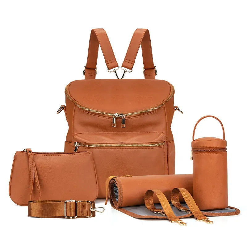 A tan leather backpack diaper bag with a front pocket and an attached clutch and strap.