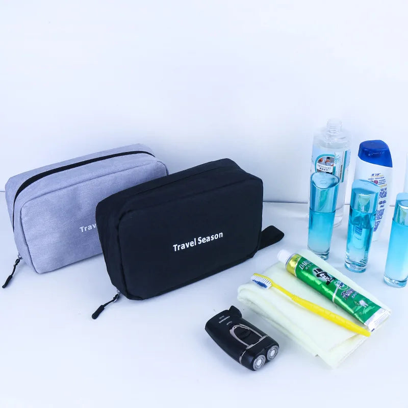 Sac de toilette imperméable noir suspendu à côté de produits de toilette et d'une petite brosse à dents électrique.