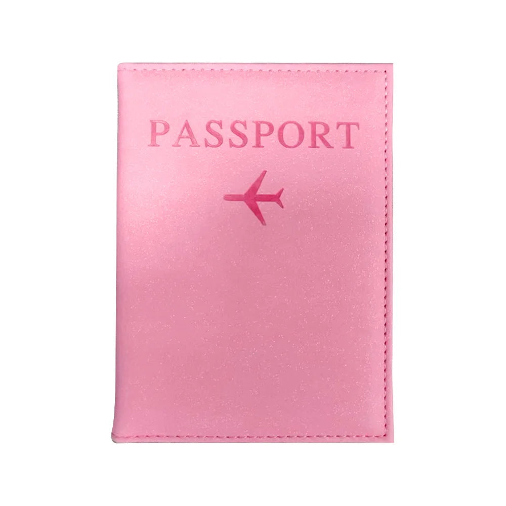 A pink leather passport holder with the word PASSPORT and a small airplane icon embossed on the cover.