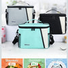 Three insulated reusable lunch bags in gray, black, and mint green are displayed with food items.