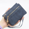 A hand holds a dark blue retro PU leather double fold wallet with a gold zipper and leather strap.
