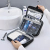 A hand opens a black portable PU leather cosmetic organizer bag revealing various grooming products.