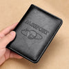 A black genuine leather passport holder with the word PASSPORT embossed and a globe design is held in a hand.