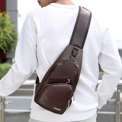 A brown men's chest bag with a strap is worn across a white long-sleeved shirt.