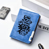 A blue leather wallet featuring a black cartoon print on the cover, placed next to a silver metal case.