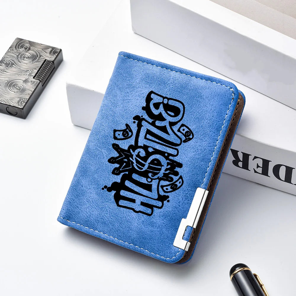 A blue leather wallet featuring a black cartoon print on the cover, placed next to a silver metal case.