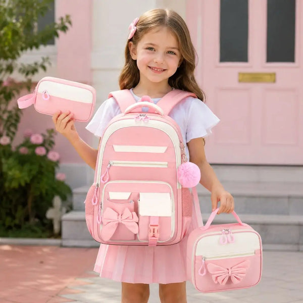 A young girl is smiling while holding a pink cartoon school bag set consisting of a backpack and a matching pouch.