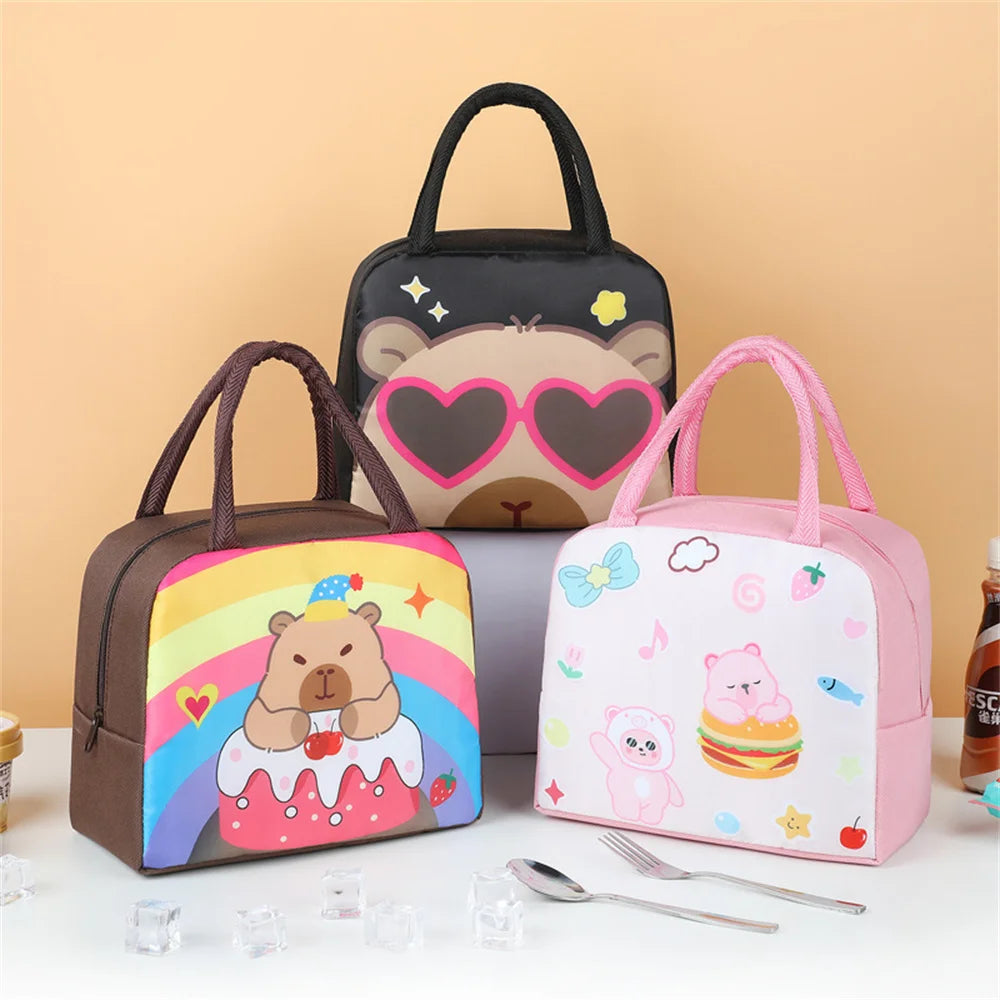 A pink and brown cartoon capybara insulated lunch bag with a black handle is displayed on a white surface.