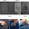 A black leather passport holder wallet shown next to a suit jacket and jeans.