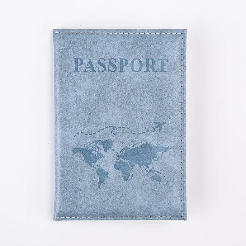 A light blue suede passport holder with the word PASSPORT and a world map design.