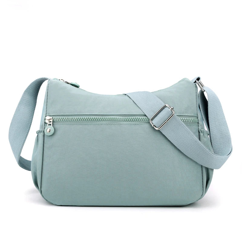 A light blue waterproof nylon crossbody shoulder bag with a zipper and strap.