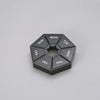 A black, hexagonal weekly pill organizer divided into seven sections labeled with the days of the week.