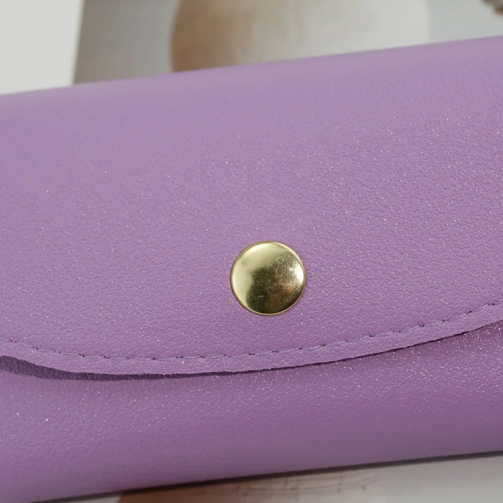 A purple PU leather hard shell sunglasses case with a gold-colored button closure.