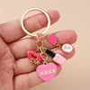 Gold-toned enamel heart keychain featuring pink and black accents.