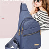 Eine Frau hält eine blaue gesteppte Damenhandtasche mit Trageriemen, trägt Sonnenbrille und gestreiftes Hemd.