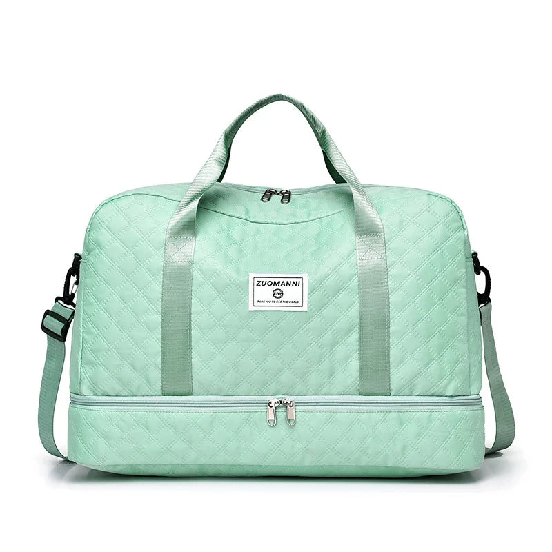 A mint green duffle bag with light green quilted fabric and a canvas strap.