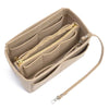 A tan felt purse organizer insert with a gold-toned zipper and leather strap.