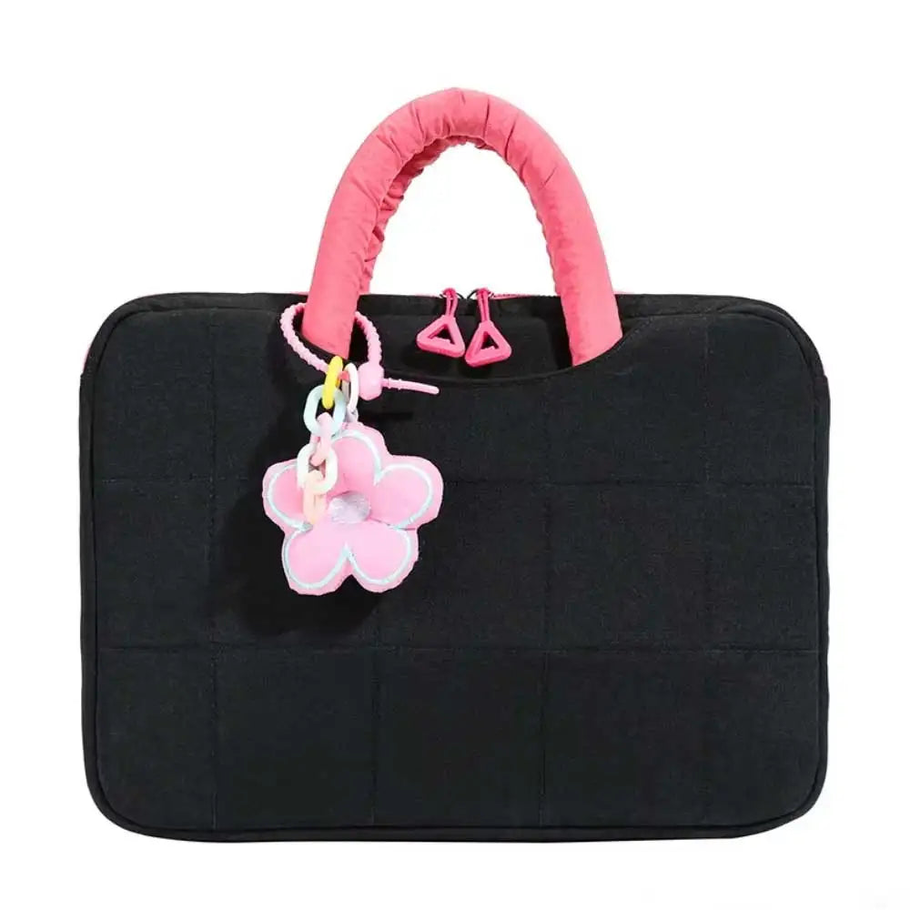 Black quilted laptop sleeve with a pink fabric handle and decorative flower charm