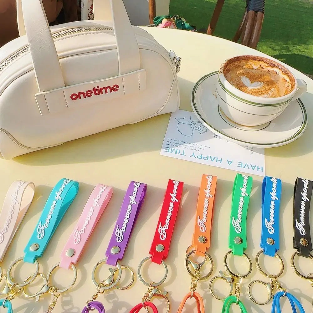 A collection of silicone heart beach bag keychains in various colors and finishes displayed on a table.