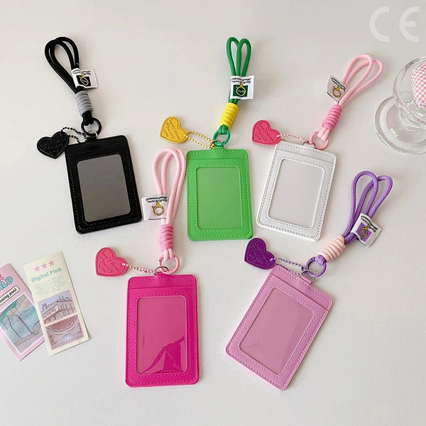 A collection of pink, green, and purple PU credit card and ID holders attached to keychains.
