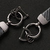 A close-up of a silver carbon fiber leather keychain with a split ring and clasp.