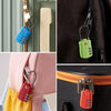 Close-up view of various TSA-approved cable locks in blue, green, and red colors attached to luggage.
