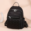 Black waterproof women's travel backpack with zippered compartments and quilted texture