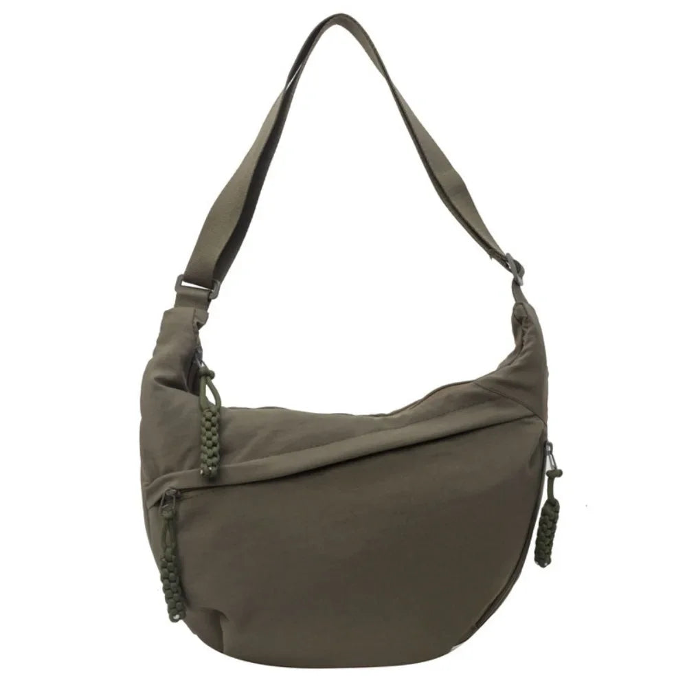 A dark olive green canvas crossbody bag with a long strap.