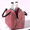 Red and white striped insulated lunch tote bag with a zippered pocket and a shoulder strap
