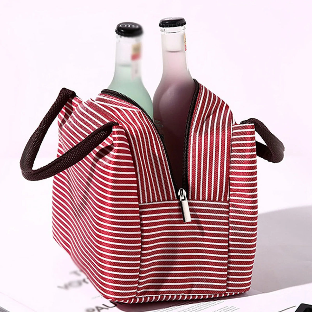 Red and white striped insulated lunch tote bag with a zippered pocket and a shoulder strap
