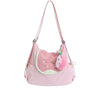 A pink nylon messenger backpack with a light pink fabric and a white fluffy pom-pom charm.